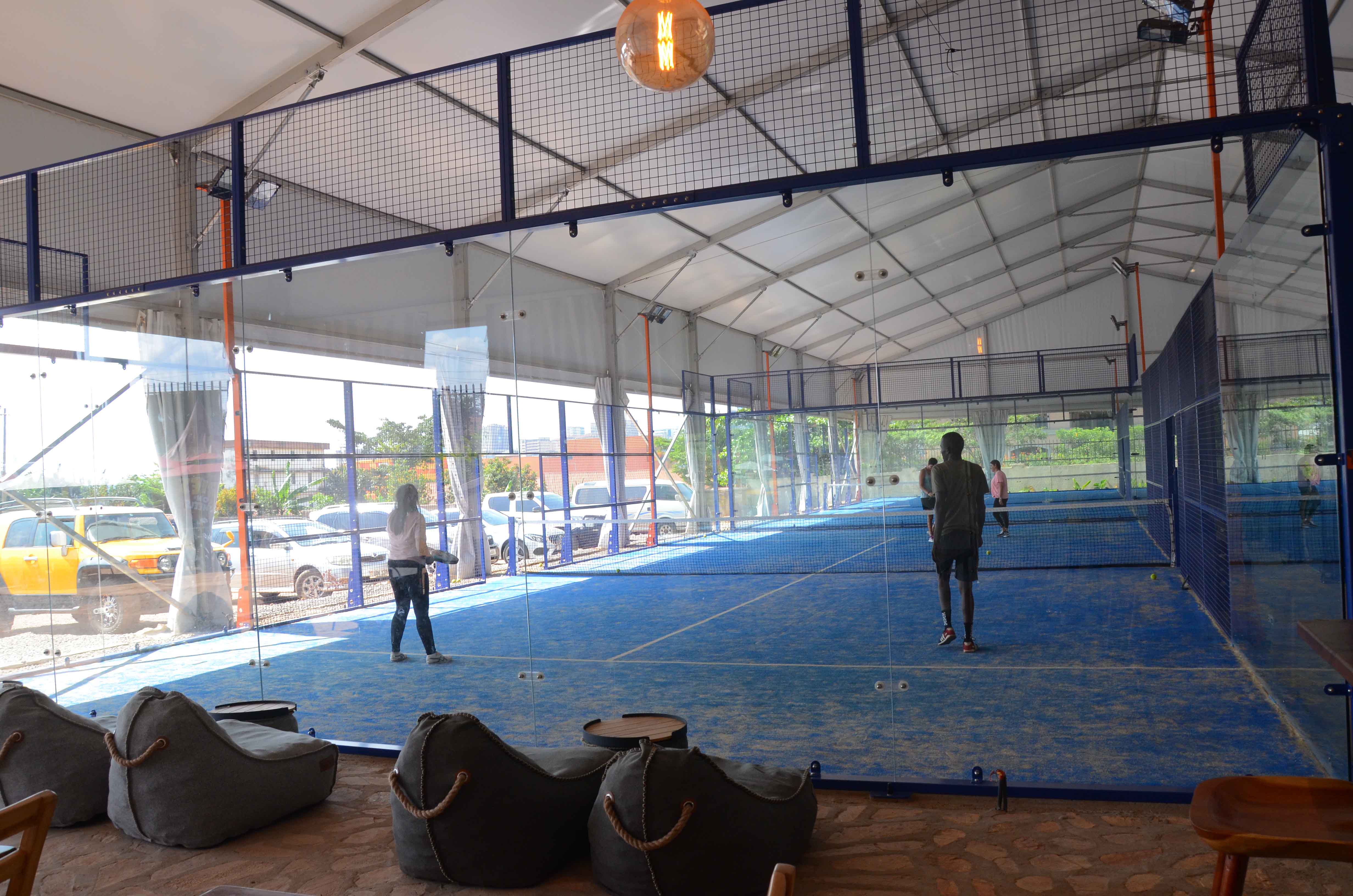 Players actively playing padel on an outdoor court with solid padel rackets