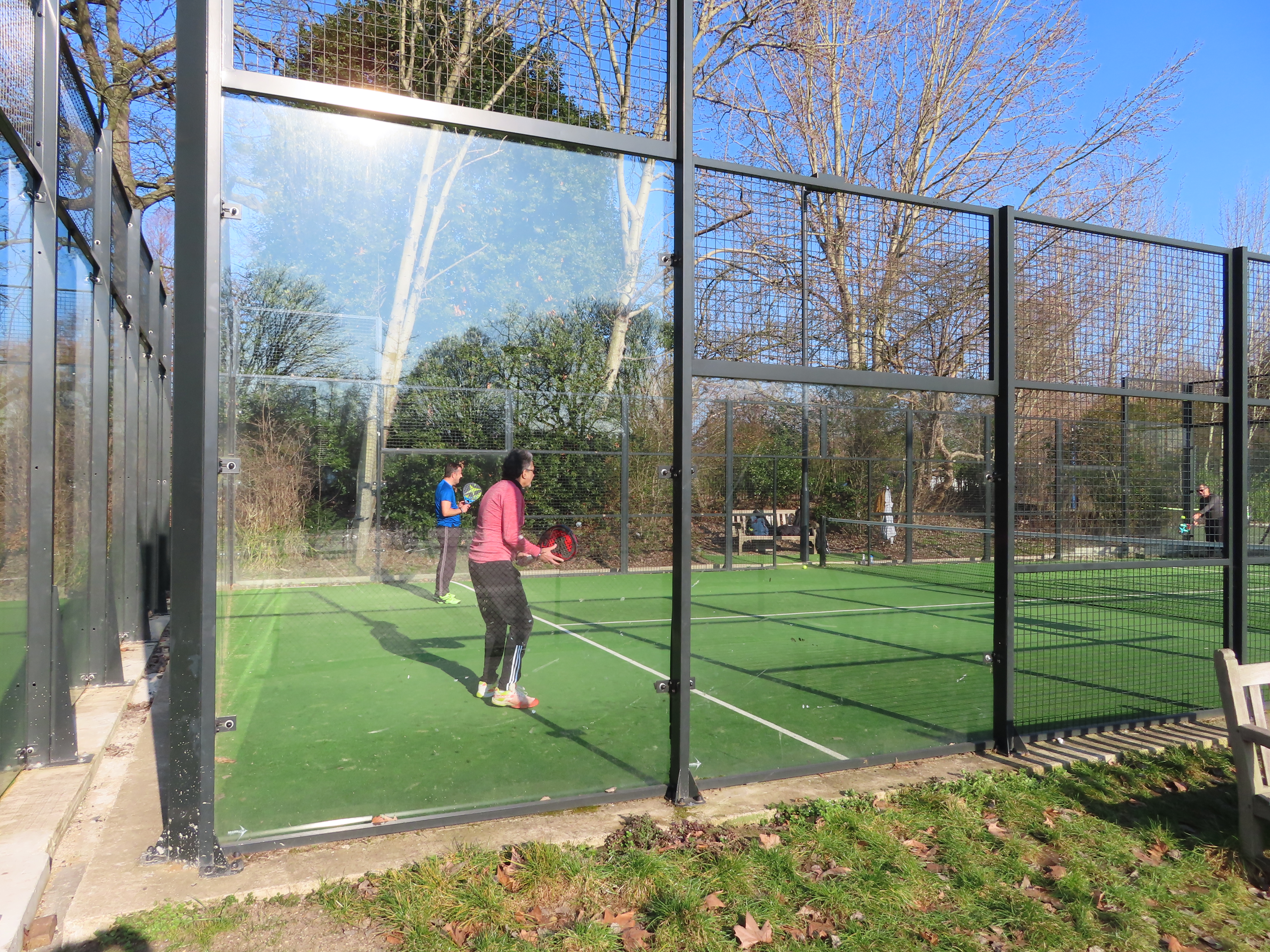 Outdoor padel court showing panoramic glass walls